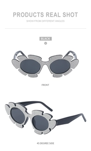 Close-up of sparkling flower shaped sunglasses with silver glitter and black lenses