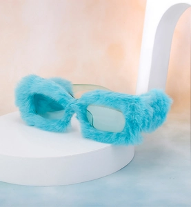 Close-up of light blue plush fur texture on square sunglasses frame with blue lenses