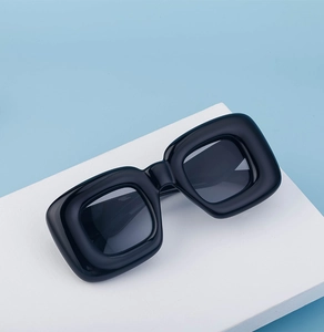 Detailed top-down view of oversized black chunky square sunglasses on a display stand