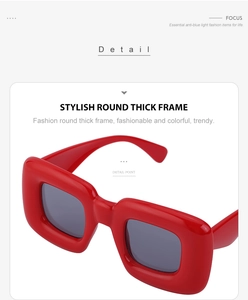 Detail view of thick red square frames with dark gray lenses and premium glossy finish