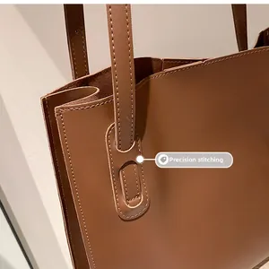 Detail showing precision stitching on the caramel brown leather tote bag handle