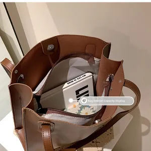 Interior of brown leather tote bag showing spacious compartments and herringbone lining