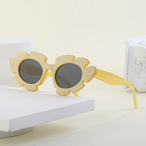 Stylish yellow flower-shaped sunglasses with glitter frame on minimalist stone base