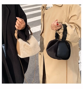 Detail of plush faux fur tote bags with braided handles and metal chain in urban setting