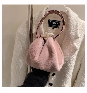 Detailed close-up of pink faux fur handbag with stylish circular decorative handle