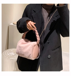 Detailed view of pink faux fur handbag with gold chain strap and beaded handle