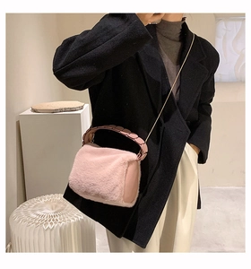 Detail of pink faux fur crossbody bag with gold chain strap and plush texture
