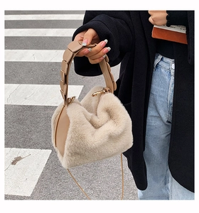 Detail of fuzzy beige faux fur handbag with unique leather petal handle design