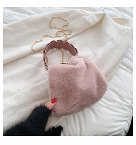 Close-up of pink faux fur handbag featuring metallic chain strap and scalloped handle