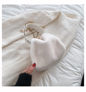 Detail of white faux fur handbag with leather handle and golden metal chain strap