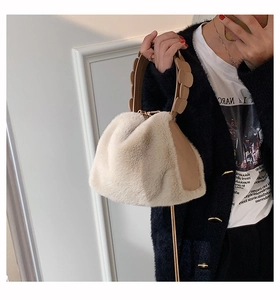 Detail of soft cream faux fur handbag with brown scalloped leather handle on model