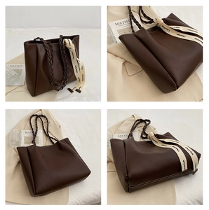 Détail d'un sac cabas marron foncé avec anse tressée et ruban décoratif élégant