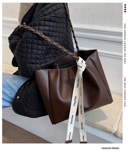 Gros plan du sac cabas marron mat avec poignée tressée et détails en cuir texturé