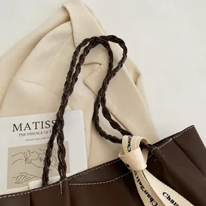Gros plan détaillé de la bandoulière tressée marron foncé d'un sac cabas chic