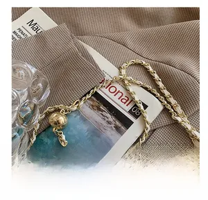 Detail of white leather woven chain strap with golden metal ball adjuster for handbag