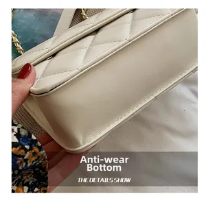 Detail showing the wear-resistant bottom and fine stitching of the cream white crossbody bag