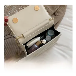 Detail show of open beige quilted chain bag interior with cosmetics for daily use