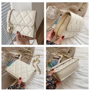 Detail of white quilted chain bag with adjustable gold ball buckle and leather strap