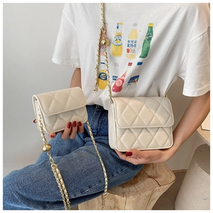 Detail view of cream quilted crossbody bags in medium and mini sizes with chain straps