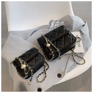 Detail of black quilted leather crossbody bags with golden chain straps in two sizes