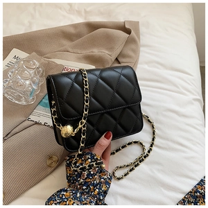 Detail of black quilted leather bag with golden chain and adjustable metal ball