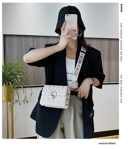 White quilted crossbody bag with golden round buckle and ethnic embroidered wide strap