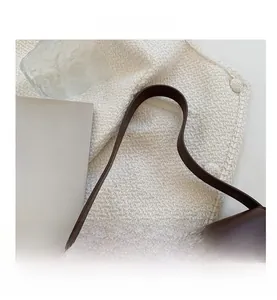 Détail de la bandoulière en cuir marron lisse avec des coutures de qualité