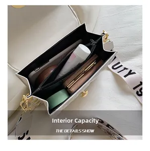 Detail showing the internal capacity and black lining of the white quilted crossbody bag