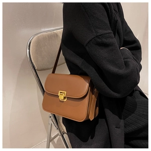 Gros plan détaillé d'un sac bandoulière vintage marron avec boucle en métal doré mat