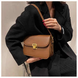 Gros plan d'un sac à bandoulière en cuir marron vintage avec un fermoir doré mat