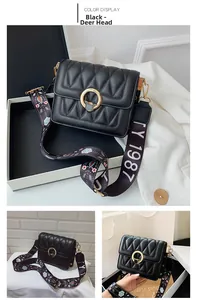 Detail of black V-quilted crossbody bag with deer head clasp and floral wide strap