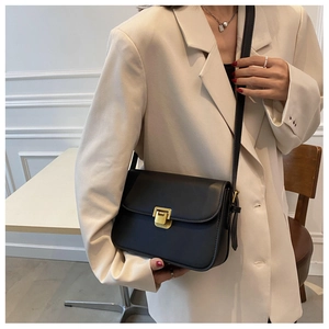 Détail du sac bandoulière noir minimaliste avec une boucle en métal doré classique