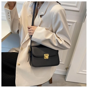Vue détaillée d'un sac bandoulière en cuir noir avec un fermoir doré métallique classique