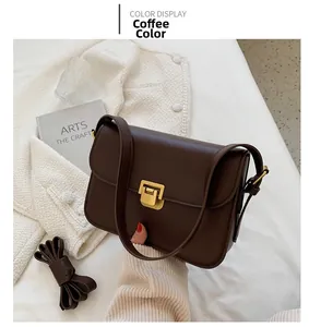 Détail macro du sac en cuir marron avec fermoir doré et bandoulière réglable