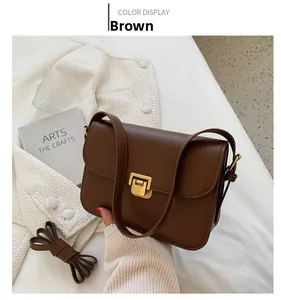 Détail du sac carré rétro marron avec fermoir métallique doré et bandoulière réglable