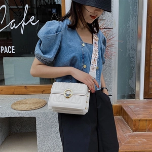 White quilted crossbody bag with gold deer buckle and embroidered wide shoulder strap