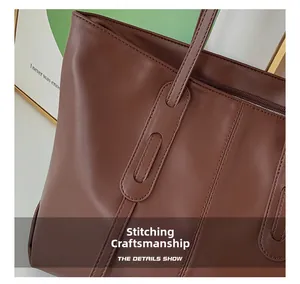 Detail shot of the fine stitching and metallic zipper on this dark brown tote bag