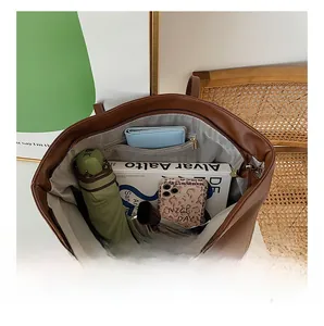 Detailed interior of brown tote bag showing large capacity for books and daily essentials