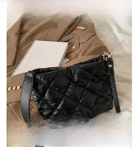 Quilted black nylon bucket bag with golden buckle on elegant brown suit fabric