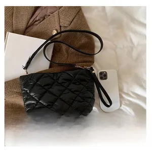Detailed view of black quilted bucket bag with leather strap on aesthetic lifestyle background