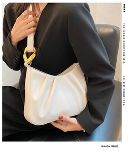 Detail view of off-white pleated hobo bag with thick gold-tone chain hardware