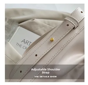 Close-up of adjustable cream leather shoulder strap with a golden metal buckle