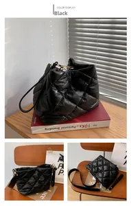 Close-up of black quilted bucket bag featuring glossy PU leather and golden hardware