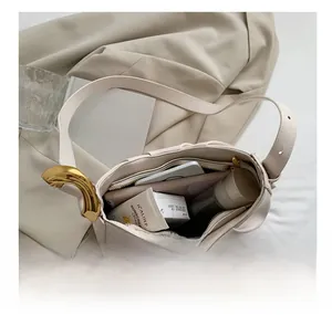 Interior storage view of cream cloud bucket bag showing phone and cosmetics capacity