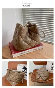 Detail view of khaki quilted bucket bag with gold hardware and embroidery textures