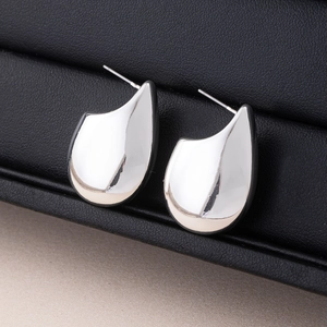 Macro shot of polished silver drop earrings showing S925 hallmark on a leather jewelry box