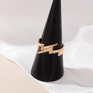 Minimalist gold lightning bolt open ring displayed on a black jewelry stand with fabric