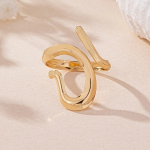 Macro shot of gold abstract linear open ring with irregular geometric curves and mirror finish