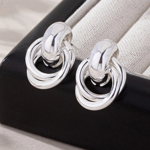 Polished silver geometric triple interlocking hoop earrings in a jewelry box
