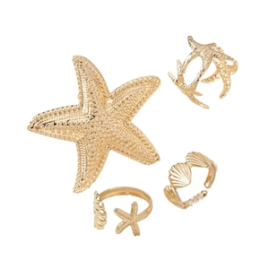 Set di 4 gioielli dorati a tema marino con anelli a stella marina e dettagli corallo